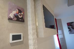 a wall with a television and a painting on a wall at Vicolo Mincio Home in Salionze