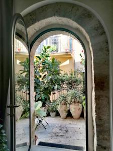 an archway with potted plants in a courtyard at Residenza Bagolino in Alcamo