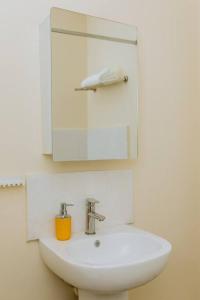 a bathroom with a white sink and a mirror at Kunyumba Luxury Homes in Lusaka