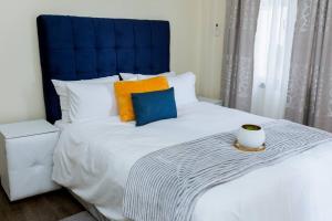 a bedroom with a large bed with a blue headboard at Kunyumba Luxury Homes in Lusaka