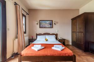 een slaapkamer met een bed met twee handdoeken erop bij Hotel Marina in Anogia