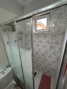łazienka z prysznicem, toaletą i oknem w obiekcie Lux Garden Home D w mieście Kumanowo