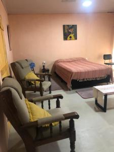 a bedroom with a bed and chairs in a room at Casita céntrica 1 in Trinidad