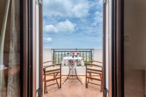 balcón con mesa, sillas y vistas al océano en Hotel Marina, en Anógeia