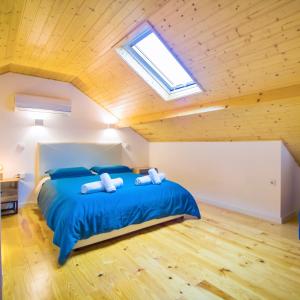 a bedroom with a bed with blue sheets and a skylight at Porto Domus 210 Penthouse in Porto