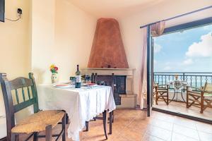 a dining room with a table and a fireplace at Hotel Marina in Anogeia