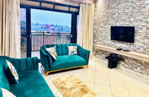 a living room with a green couch and a tv at Trendy apartments in Entebbe