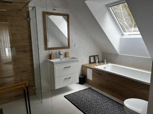 a bathroom with a tub and a sink and a mirror at Villa Toscana in Gietrzwałd
