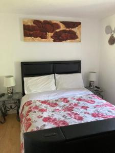 a bedroom with a bed with a floral bedspread and two tables at Mountain View 