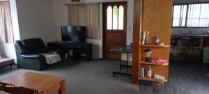 uma sala de estar com um sofá e uma televisão em City Bungalow em Tauranga