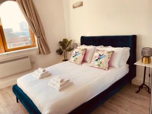 1 dormitorio con 1 cama con toallas en Spacious 2 Bedroom City pad in Old Street London, en Londres