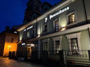 a building with a sign on it at night at U Dominicana in Kamianets-Podilskyi