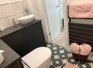 曼徹斯特的住宿－Private entrance 1 bed studio near Salford Royal，浴室配有白色卫生间和盥洗盆。