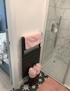 uma casa de banho com um chuveiro e toalhas cor-de-rosa em Private entrance 1 bed studio near Salford Royal em Manchester