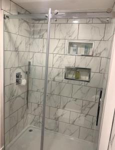 a shower with a glass door in a bathroom at Private entrance 1 bed studio near Salford Royal in Manchester