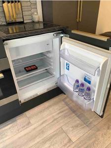 an open refrigerator with bottles of water in it at Private entrance 1 bed studio near Salford Royal in Manchester