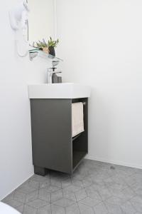 baño con lavabo en una pared blanca en O'LIVE PREMIUM Mobile Home, en Drage