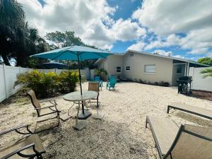 a patio with a table and chairs and an umbrella at Beach Villa A in Clearwater Beach