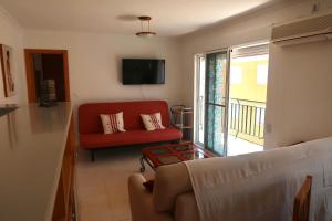un soggiorno con divano rosso e TV di Apartamento Cullera Playa San Antonio II a Cullera