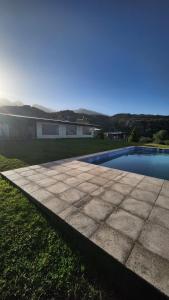 a backyard with a swimming pool and a house at Kairos Cabañas in Las Compuertas