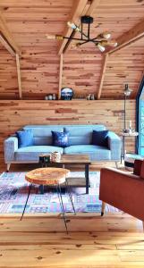 een woonkamer met een blauwe bank en een tafel bij bungalov in Rize