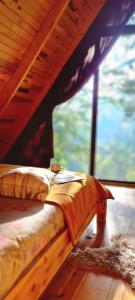 Cama en habitación con ventana grande en bungalov en Rize