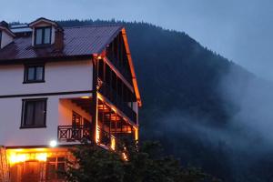 a building with lights on the side of a mountain at ÇAYKARA-NANAGA 1883 Four bedroom villa in Çaykara +50 photos