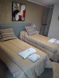 Dos camas en una habitación con toallas. en Apartamento Alvear en San Rafael