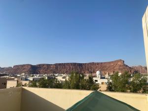 Blick auf eine Stadt mit einem Berg im Hintergrund in der Unterkunft Wind alula in Al-'Ula