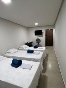 eine Reihe von 4 Betten in einem Zimmer mit einem TV in der Unterkunft Acomodação aconchegante próximo ao centro in Garanhuns