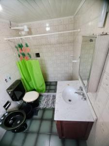 een badkamer met een wastafel, een toilet en een spiegel bij Hospedagem da Val in Paraty