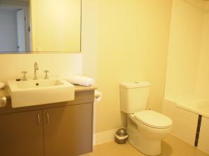 a white toilet sitting next to a sink in a bathroom at Edge Apartments Cairns in Cairns