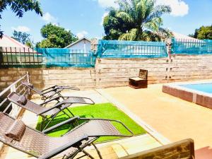 um par de cadeiras sentadas ao lado de uma piscina em Trendy apartments em Entebbe