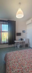 Habitación con cama, mesa y escritorio. en Affittacamere Villa Zelinda en Sirolo
