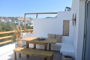 una mesa pequeña y un banco en un balcón en Lipsi Sands, en Lipsi