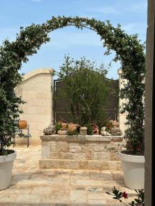 un arco con piante e fiori in un giardino di Villa Luis a Fasano