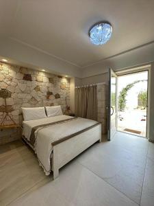 1 dormitorio con cama y pared de piedra en Villa Luis, en Fasano