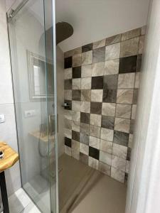 a bathroom with a shower with a tiled wall at Villa Luis in Fasano