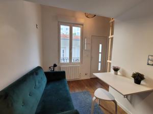 a living room with a blue couch and a table at 3D- Studio tout équipé avec cuisine 10 mins de Paris in Issy-les-Moulineaux