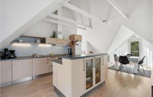 an attic kitchen with white cabinets and a table at Stunning Apartment In Blvand With 1 Bedrooms And Wifi in Blåvand