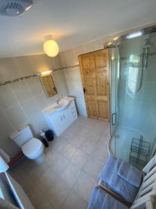 y baño con aseo, lavabo y ducha. en JMD Lodge - Self Catering Property in the heart of The Burren between Ballyvaughan, Lisdoonvarna, Doolin and Kilfenora in County Clare Ireland en Ballyvaughan