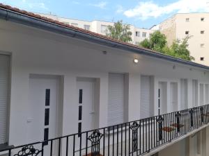 a row of white doors on a balcony at 3D- Studio tout équipé avec cuisine 10 mins de Paris in Issy-les-Moulineaux