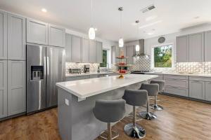 a kitchen with white cabinets and a large island with bar stools at Fabulous Beach Get Away - Brand New Beach House in Half Moon Bay