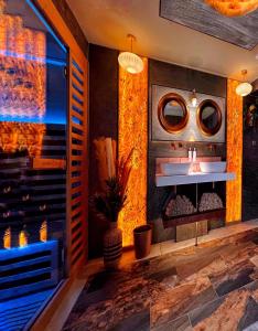 a room with a fireplace with a sink and a mirror at Hambrook Guest Suites and Private ESPA Spa in Canterbury