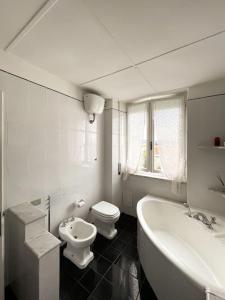 a bathroom with a tub and a toilet and a sink at Tra Cielo e Mare in Follonica +17 photos