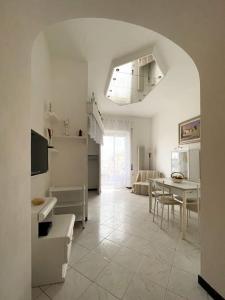 a white kitchen with a table and a dining room at Tra Cielo e Mare in Follonica