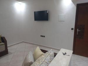 sala de estar con sofá y TV en la pared en Rawan Appart en Tánger