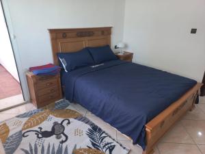 1 dormitorio con 1 cama con edredón azul en Rawan Appart en Tánger