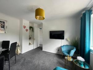 a living room with a couch and a tv on a wall at Large Stylish 2 Bedroom Apartment Stevenage Sleep 6 in Stevenage