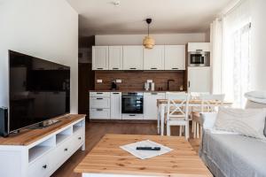 a kitchen and living room with a couch and a table at Apartmány Bešeň in Bešeňová